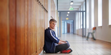 Florian sitzt im Flur der Staatlichen Studienakademie Glauchau.