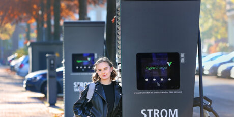 Alona lehnt an einer Strom-Tanksäule.